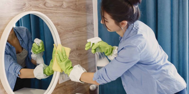 Aide à domicile qui nettoie un miroir